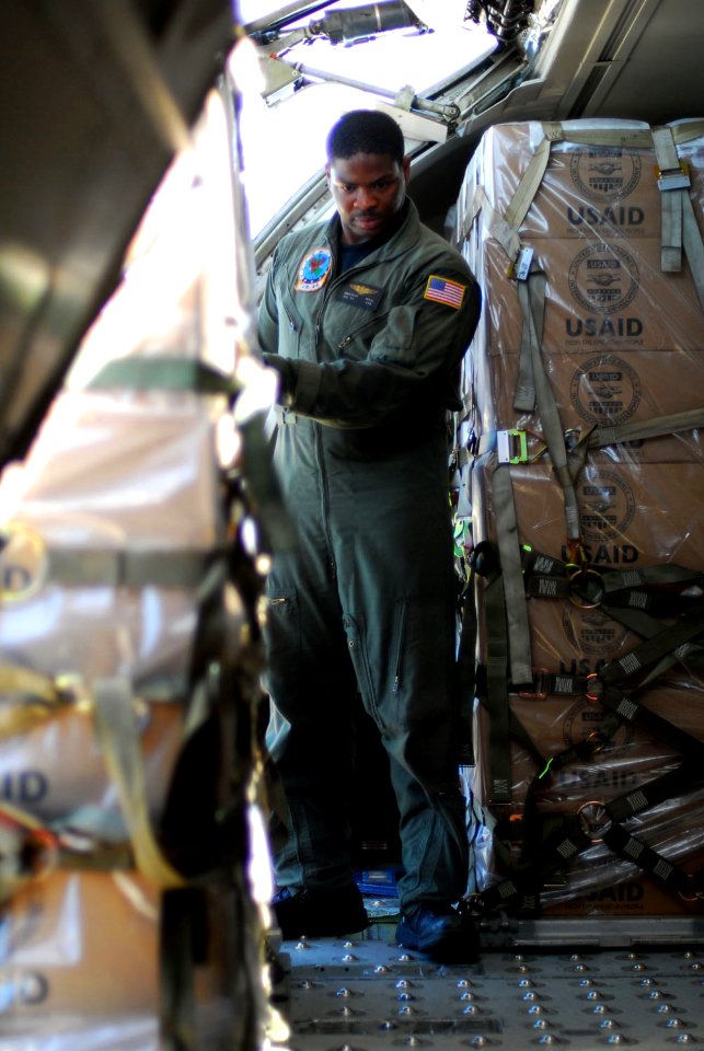 US Navy 080818-N-5821P-043 Aircraft Structural Mechanic 3rd Class Jonathan Mack guides a pallet onto a C-9B Skytrain as the aircraft loads humanitarian supplies