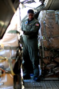 US Navy 080818-N-5821P-043 Aircraft Structural Mechanic 3rd Class Jonathan Mack guides a pallet onto a C-9B Skytrain as the aircraft loads humanitarian supplies