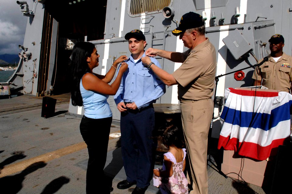 US Navy 080818-N-8273J-288 Engineman 2nd Class Jerry Valdez has 2nd class petty officer crows pinned on him by Chief of Naval Operations (CNO) Adm. Gary Roughead, right, and his wife and daughter after Valdez is promoted