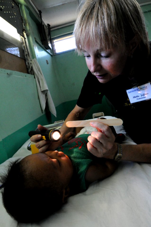 US Navy 080818-N-9774H-035 Pediatrician Rhonda Jefferies, an Operation Smile volunteer embarked aboard the amphibious assault ship USS Kearsarge (LHD 3), conducts a physical exam on a 9-month-old infant during Continuing Promis