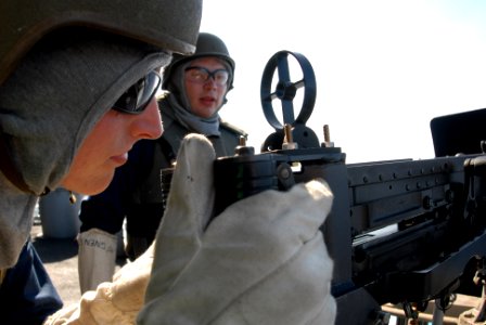 US Navy 080816-N-7730P-052 Gunner's Mate Seaman Brian Utne sites in a .50-caliber machine gun in preparation to fire 200 .50 caliber rounds at a floating target (Killer Tomato) during a training exercise aboard the Nimitz class