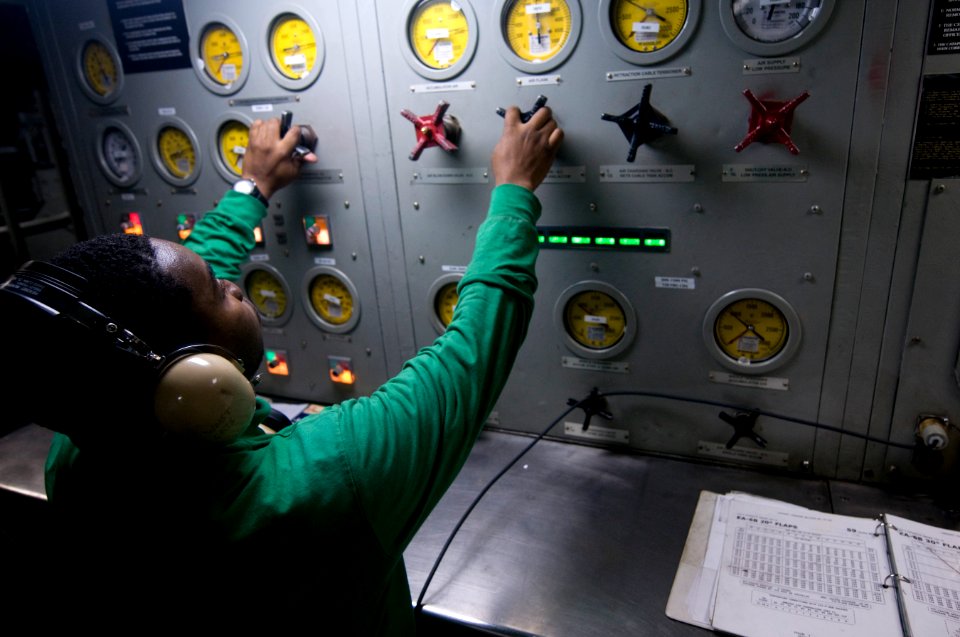 US Navy 120102-N-TZ605-305 A Sailor makes adjustments to steam valves that control aircraft catapults