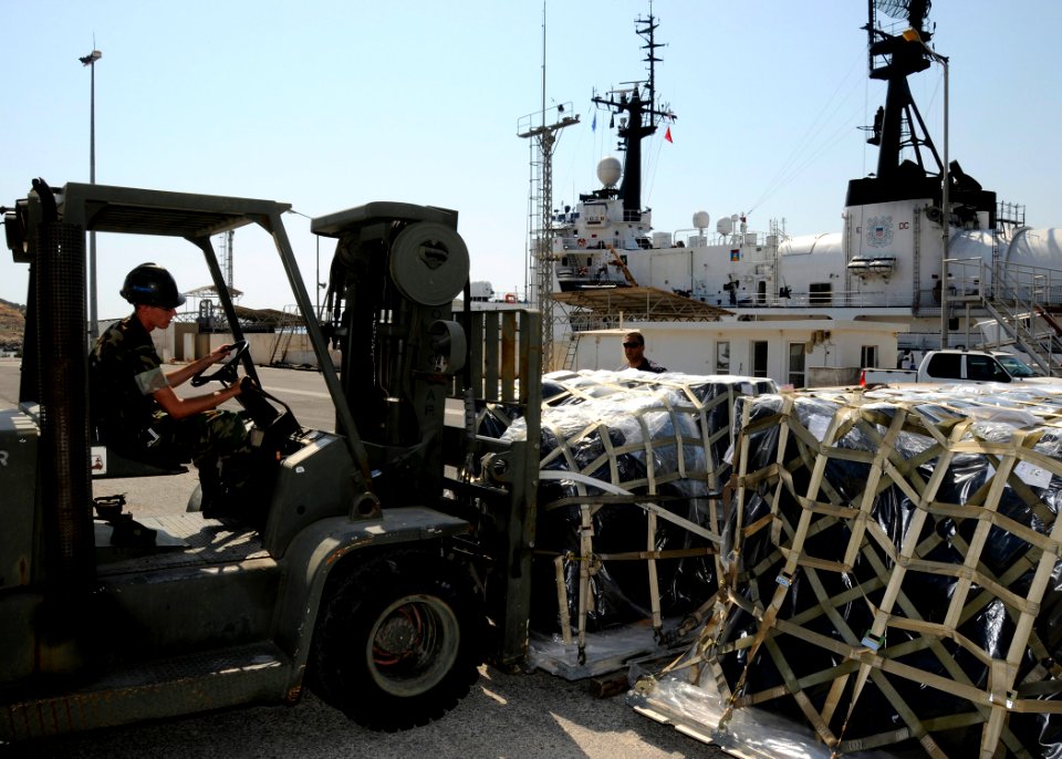US Navy 080821-N-0780F-004 Construction Mechanic 1st Class Timothy Fox uses a forklift to place pallets of supplies on the pier