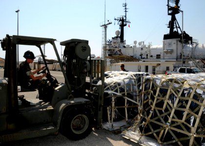 US Navy 080821-N-0780F-004 Construction Mechanic 1st Class Timothy Fox uses a forklift to place pallets of supplies on the pier