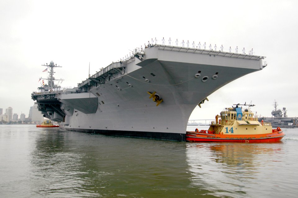 US Navy 080821-N-7029R-045 The aircraft carrier USS Kitty Hawk (CV 63), far right, remains moored to the pier as tugboats assist the aircraft carrier USS George Washington (CVN 73) depart Naval Air Station North Island