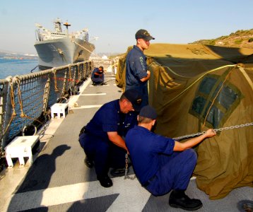 US Navy 080822-N-0780F-001 Crewmembers aboard the U.S. Coast Guard Cutter Dallas (WHEC 716) cover and secure a cargo of supplies