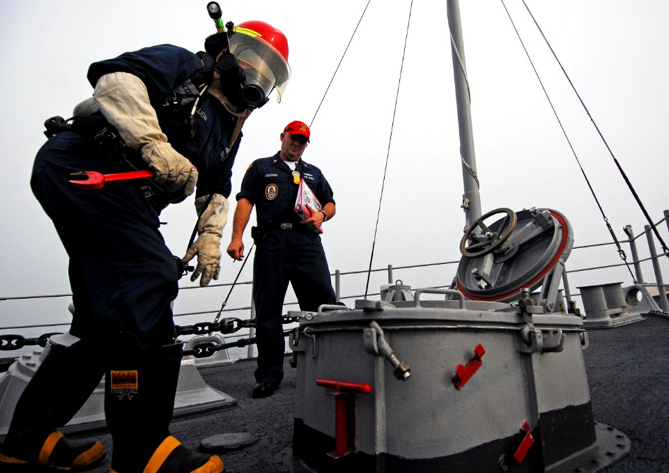 US Navy 080819-N-0807W-146 A Sailor wearing a self-contained breathing apparatus prepares to open a scuttle