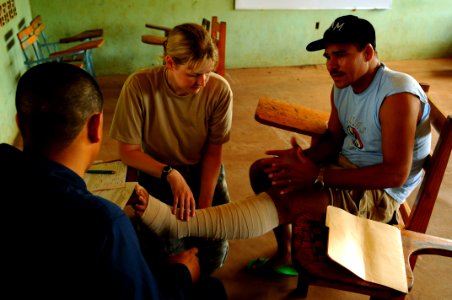 US Navy 080820-N-4515N-003 Air Force Capt. Amber Tyler wraps the leg of a cancer patient