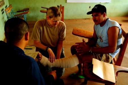 US Navy 080820-N-4515N-003 Air Force Capt. Amber Tyler wraps the leg of a cancer patient photo