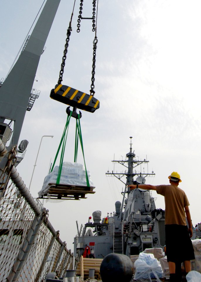 US Navy 080825-N-4044H-050 Boatswain's Mate 2nd Class Santos R. Torres guides the crane barge driver aboard the guided-missile destroyer USS McFaul (DDG 74)