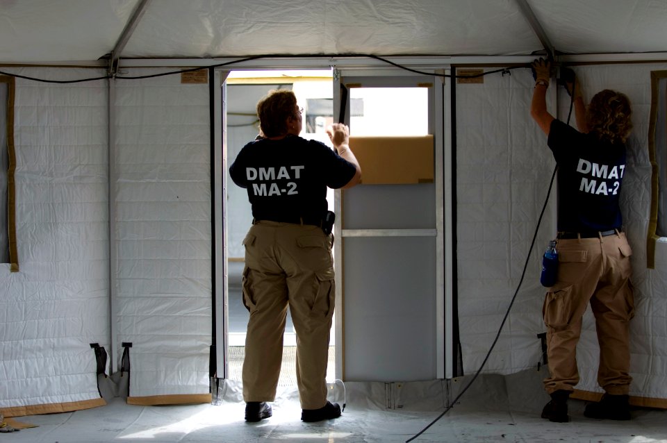 US Navy 080903-N-4154B-060 Two members from the FEMA Disaster Medical Assistance Team run lighting cords and lights