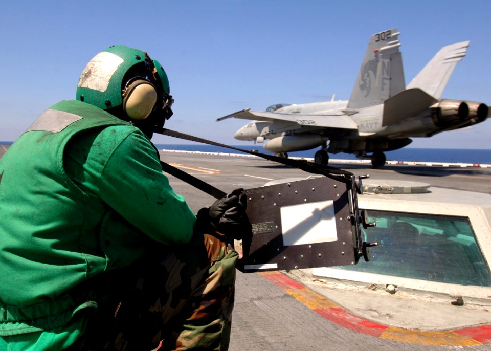 US Navy 080823-N-7282P-038 An aviation boatswain mate flashes the wait time as an F-A-18C Hornet from the
