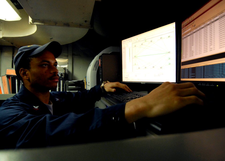 US Navy 080823-N-9079D-035 Information Systems Technician 2nd Class Neal G. Lyons, from Lawnside, N.J., troubleshoots SIPRNET switchers in the tactical automated information systems center aboard the aircraft carrier USS Abraha