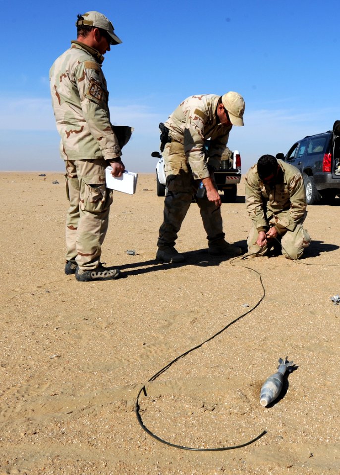 US Navy 111214-N-BA263-610 Chief Explosive Ordnance Disposal Technician Matt Clausen, center, instructs Lt. j.g. Jacob Mello on knot tying techniqu