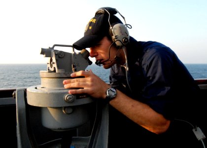 US Navy 080822-N-4044H-002 Quartermaster Seaman Apprentice Derek Evoy looks through a telescopic alidade photo