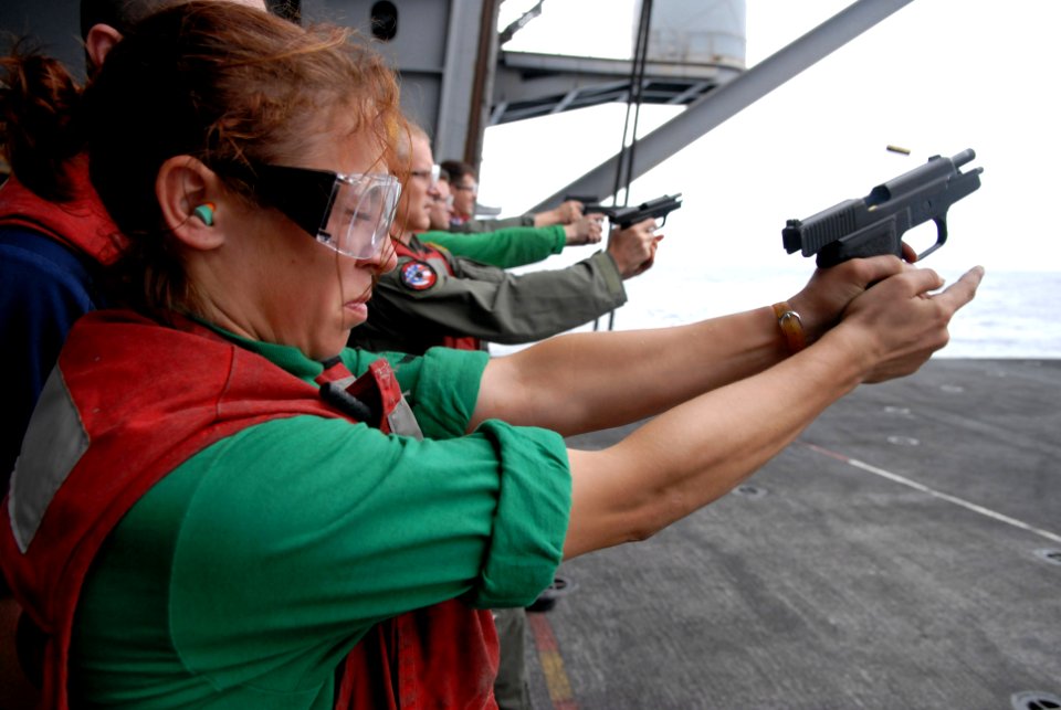US Navy 080824-N-4005H-367 Aviation Structural Mechanic 3rd Class Erika Mata fires a 9 mm pistol at a target during a small-arms weapons qualifying exercise aboard the Nimitz-class aircraft carrier USS Ronald Reagan (CVN 76)