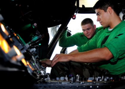 US Navy 080825-N-8534H-001 Aviation Electrician's Mate 3rd Class Alvaro Mercado inspects navigational instruments in a Seahawk helicopter during a routine maintenance phase while underway aboard the aircraft carrier USS George