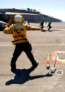 US Navy 080823-N-7282P-034 Aviation Boatswain's Mate (Handling) 3rd Class Thanh Dai signals to an F-A-18C Hornet from the