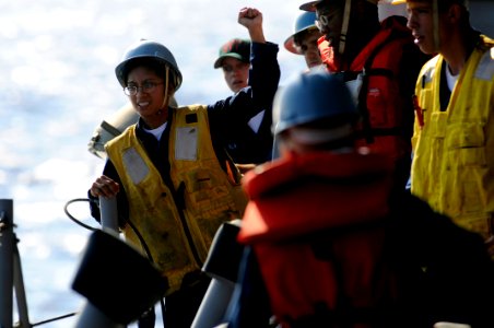 US Navy 080825-N-8546L-168 Boatswain's Mate 3rd Class Rachel Hoffman directs a davit operator to pick up a rigid hull inflatable boat after a practice man overboard recovery drill aboard the U.S. 7th Fleet amphibious command sh