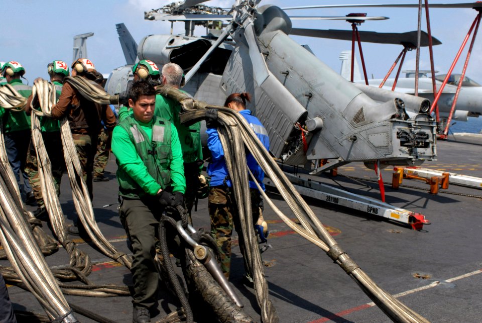US Navy 080827-N-3610L-145 An aviation boatswain's mate assists in the stowage of a barricade net