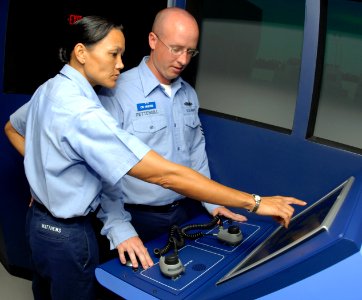 US Navy 080826-N-0995C-021 Personnel Specialist 1st Class Christina Matthews gives a pass-down to one of her fellow chief petty officer (CPO) selects on manning the navigation radar when on the bridge