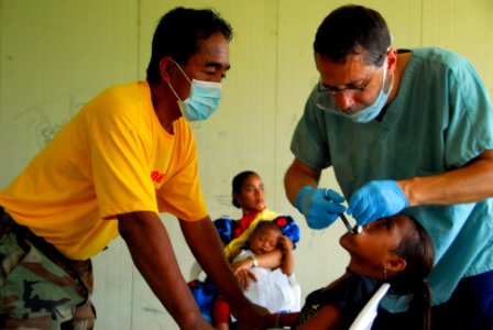 US Navy 080824-N-9689V-001 Lt. Cmdr. Rich Kolanda, a dentist from the U.S. Public Health Service, performs a tooth extraction during a Medical and Dental Civic Action Program (MEDCAP) held on Uman, an island in Chuuk State, Fed