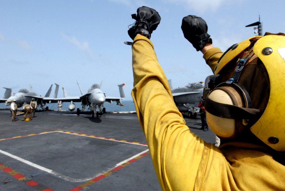 US Navy 080901-N-7730P-087 Aviation Boatswain's Mate (Handling) Airman Richard Garcia gives the pilot a hand signal