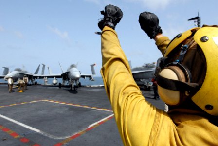 US Navy 080901-N-7730P-087 Aviation Boatswain's Mate (Handling) Airman Richard Garcia gives the pilot a hand signal