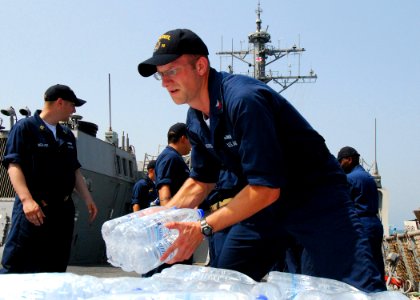 US Navy 080824-N-4044H-095 Cryptologic Technician 1st Class Jed Morris stacks bottles of water aboard the guided-missile destroyer USS McFaul (DDG 74), which will be included in the humanitarian supplies for the people of Georg