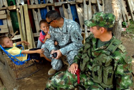 US Navy 080831-N-3595W-154 Army Lt. Col. Franky Bruno and a Colombian host nation security guard play with local children photo