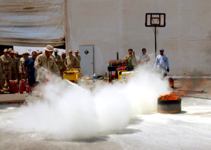 US Navy 080828-N-3560G-106 Construction Electrician 2nd Class Joseph Ulep, assigned to Naval Mobile Construction Battalion (NMCB) 4, extinguishes a class