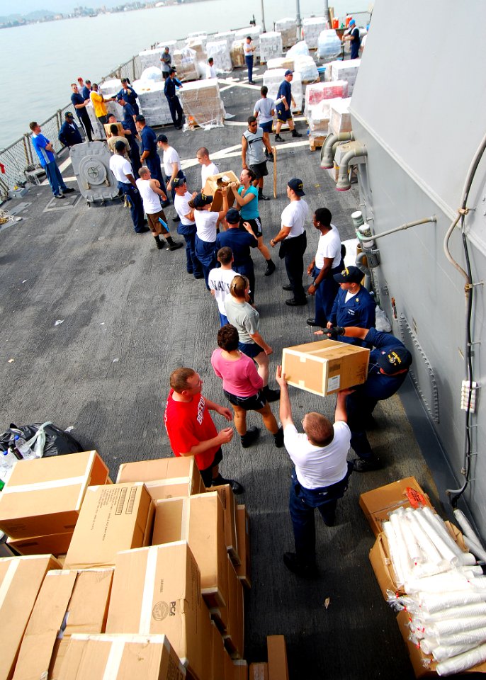 US Navy 080825-N-4044H-056 Sailors aboard the guided-missile destroyer USS McFaul (DDG 74) stack humanitarian assistance supplies to be put on pallets and then lifted from the ship to a crane barge and then given to the people