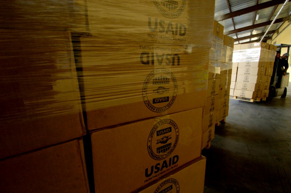 US Navy 080827-F-2902B-071 A Georgian native moves boxes of hygiene kits and meals, ready to eat by forklift