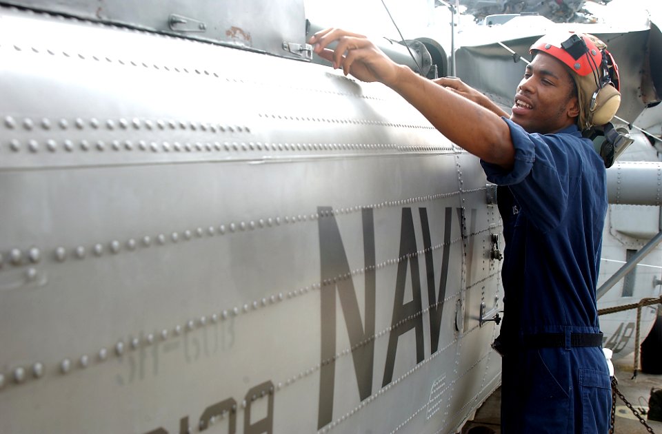US Navy 080902-N-1522S-008 Aviation Ordnanceman Airman Jerome Mckenzie inspects a helicopter drive shaft