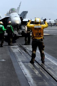 US Navy 080828-N-3659B-038 An aviation boatswain's mate (handling) gives the hand signal for the pilot of an F-A-18C Hornet assigned VFA-25 to taxi forward onto catapult 2 on the flight deck of USS Ronald Reagan (CVN 76)