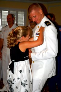 US Navy 080829-N-8629D-058 The daughter of Chief Warrant Officer (CWO) 2 Stephen Ditamore pins wings of gold on her father during a winging ceremony at Naval Air Station Corpus Christi
