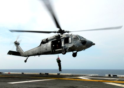 US Navy 080829-N-4236E-342 An MH-60S Sea Hawk from Helicopter Sea Combat Squadron (HSC) 26 hoists a Sailor off the flight deck of the multi-purpose amphibious assault ship USS Iwo Jima (LHD 7) photo