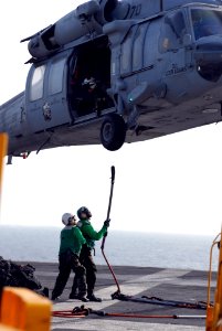 US Navy 080830-N-4995K-013 Sailors aboard the Nimitz-class aircraft carrier USS Ronald Reagan (CVN 76) ) attach a sling for transferring cargo to a MH-60S Sea Hawk assigned to the
