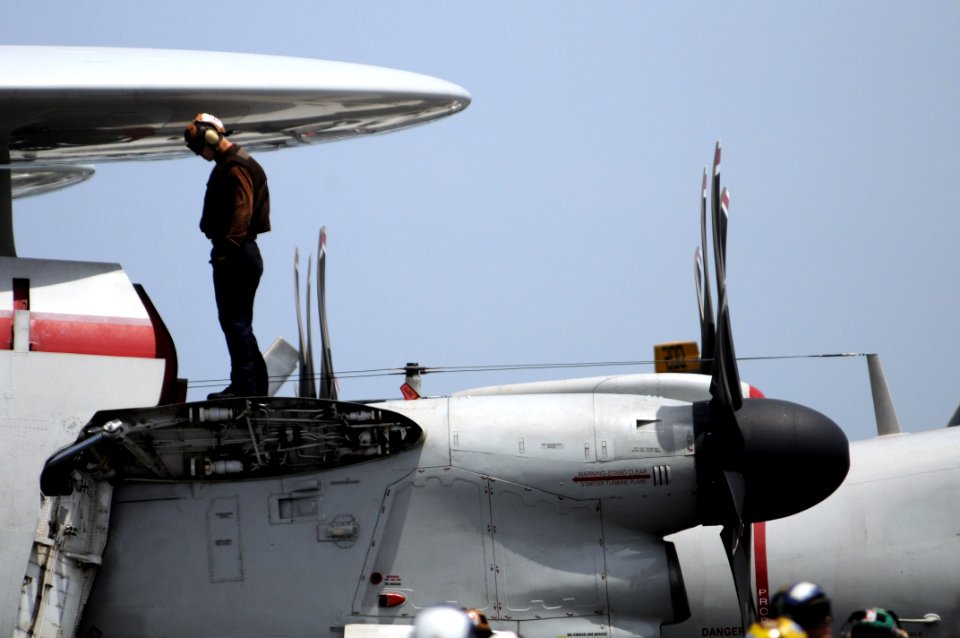 US Navy 080828-N-3659B-044 Airman Christopher Burns performs pre-flight checks on an E-2C Hawkeye on the flight deck of the Nimitz-class aircraft carrier USS Ronald Reagan (CVN 76)