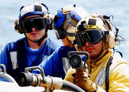 US Navy 080905-N-2183K-049 A nozzle team fights a simulated fire during a flight deck fire drill aboard the amphibious assault ship USS Peleliu (LHA 5)