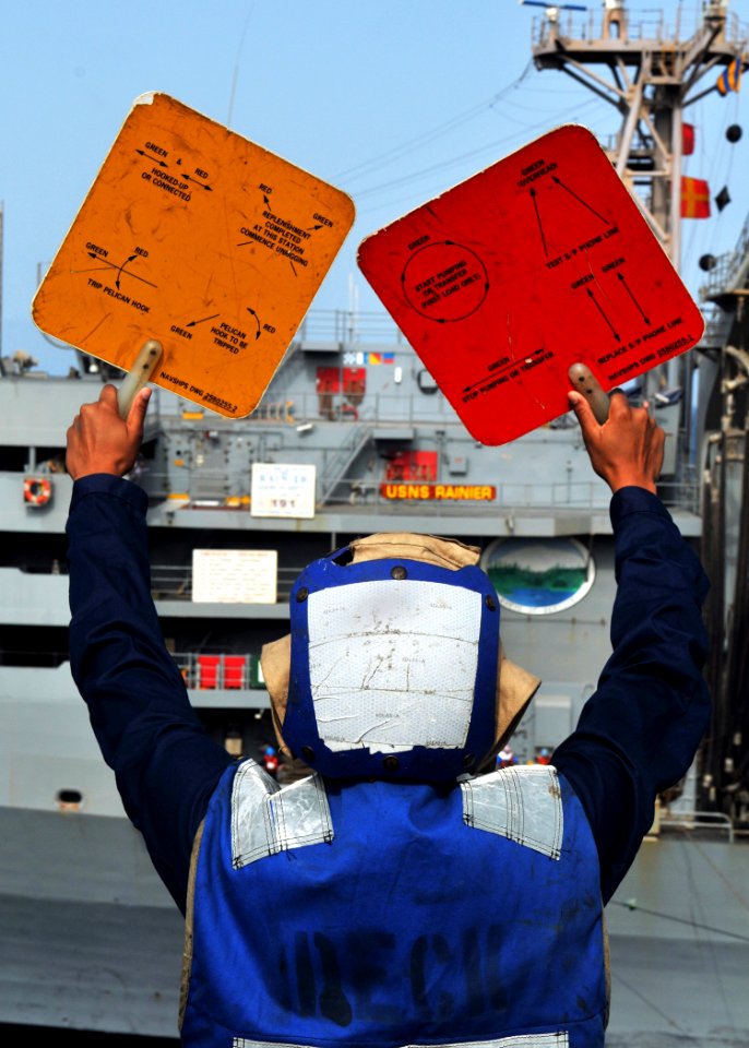 US Navy 080901-N-7981E-020 Seaman Porsche Zamarripa signals to the Military Sealift Command fast combat support ship USNS Rainer (T-AOE 7)