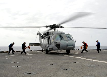 US Navy 080905-N-3392P-075 Sailors chock and chain an MH-60S Sea Hawk helicopter after it lands aboard the amphibious dock landing ship USS Carter Hall (LSD 50) for passenger transfer