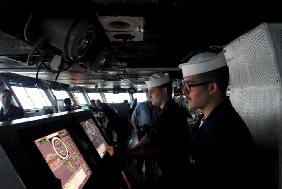 US Navy 080905-N-3610L-003 Seaman Anthony Lugo steers the Nimitz-class aircraft carrier USS Ronald Reagan (CVN 76) during flight operations while wearing his favorite hat – a Dixie cup