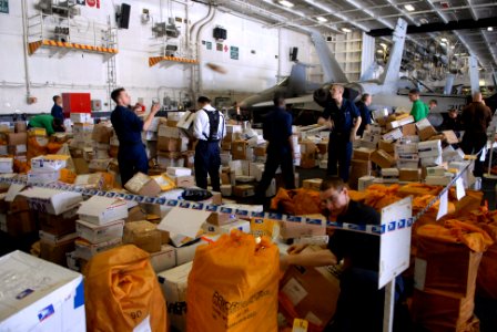 US Navy 080830-N-1635S-004 Sailors sort through 65 pallets of mail in the hangar bay of the Nimitz-class aircraft carrier USS Ronald Reagan (CVN 76) during a replenishment at sea photo