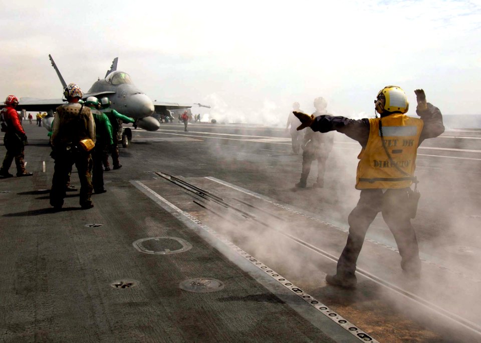 US Navy 080829-N-7282P-032 An Aviation Boatswain's Mate (Handling) directs an F-A-18C Hornet from the