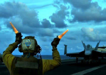 US Navy 080906-N-7981E-479 Aviation Boatswain's Mate (Handling) Airman Sean Bibby, from Dunellen, N.J., directs an F-A-18F Super Hornet into position to await launch on the flight deck of the aircraft carrier USS Abraham Lincol