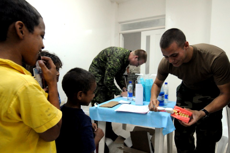 US Navy 080829-N-9774H-068 Interior Communications Electrician 3rd Class James Thomas teaches children how to properly brush their teeth