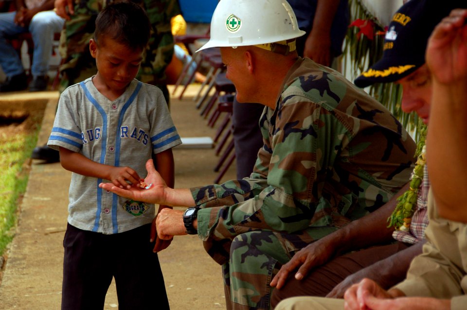 US Navy 080901-N-7498L-218 Chief Equipment Operator James Brock offers a piece of candy to a local child at the Messa Elementary School