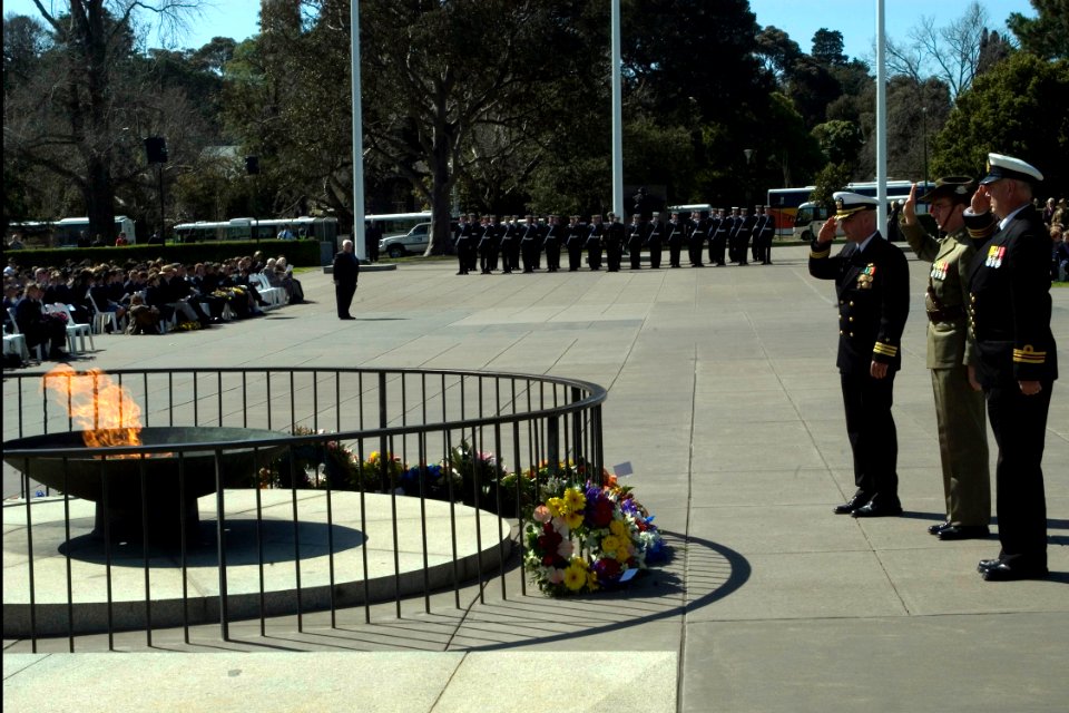 US Navy 080903-N-9123L-004 Cmdr. John S. Banigan salutes after presenting a floral tribute during the Battle for Australia commemoration ceremony