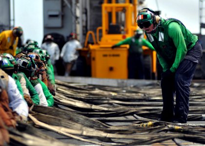 US Navy 080904-N-7981E-100 An Air Department Sailor directs flight deck personnel photo